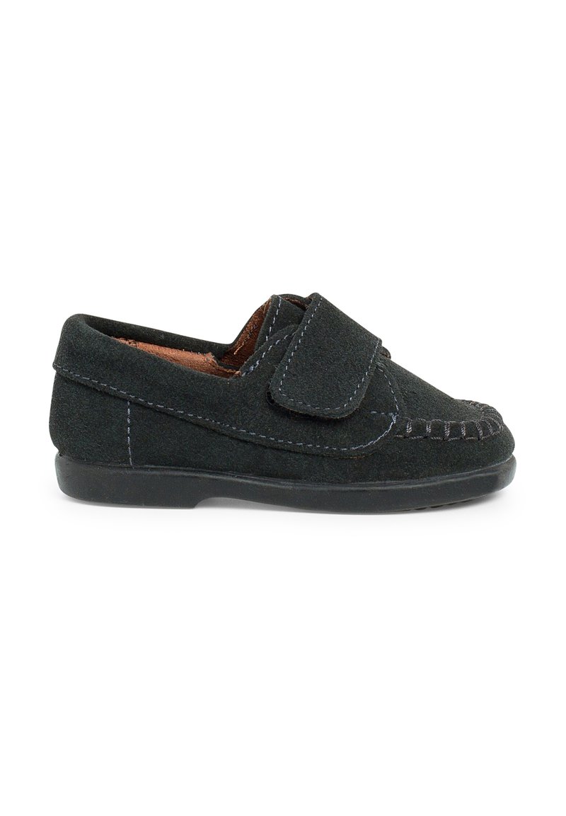 Scarpa slip-on in suede nero con una fascia in Velcro, caratterizzata da cuciture a contrasto e punta arrotondata, suola in gomma per una buona aderenza.