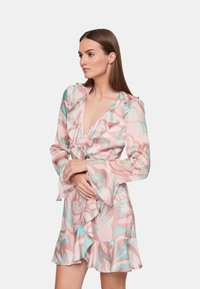 Abito a fantasia floreale in tonalità di rosa soffice e turchese. Presenta un collo e maniche a volant, un orlo svasato e un tessuto leggero.