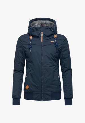 Marineblauwe geïsoleerde jas met een capuchon gevoerd met bont, elastische manchetten en een ritssluiting. Heeft bruine leren accenten en een logopatch aan de zijkant.