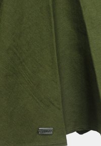 Tessuto verde oliva con una consistenza liscia, caratterizzato da un'etichetta metallica con la scritta "SUN68" sul bordo inferiore. L'indumento ha un design rilassato.