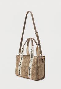 Bež shearling käekott nahkdetailidega, millel on kaks lühikest ülemist käepidet ja pikk reguleeritav rihm. Valged rihmad tekstiga "VALENTINO".