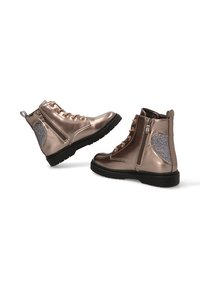 Botas de tobillo de bronce metálico con un acabado suave, cordones en la parte delantera, cremallera lateral y acentos de purpurina gris en los tacones. Suela de goma negra.