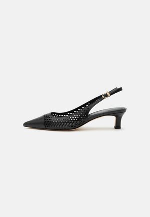 Escarpin slingback noir à talon kitten avec bout pointu et design perforé, doté d'une petite bride à boucle dorée.