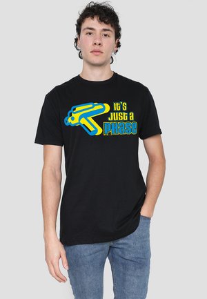 Black cotton t-shirt featuring a bold blue and yellow graphic text reading "It's just a phase," with a design resembling a toy gun.