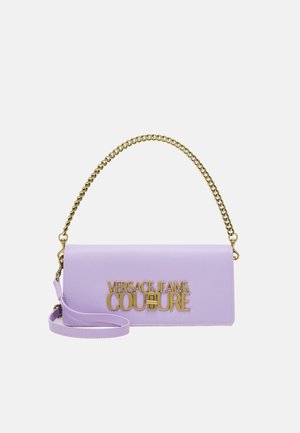 Orvokkivioletti suorakulmainen käsilaukku, jossa on kultainen ketjurempi ja "Versace Jeans Couture" -logo kullanvärisenä etutaskun läpissä.