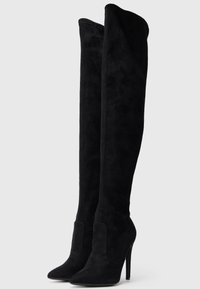 Melnas virsceļgala zābaki, izgatavoti no mīksta zamšāda, ar smailu purngalu un augstu stiletto papēdi; gluda tekstūra un bezšuvju dizains.