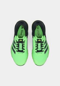 Baskets de sport vert fluo avec accents noirs, tige en mesh, semelles texturées et détails de marque proéminents. Design à lacets pour un maintien sécurisé.