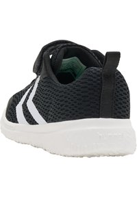 Scarpe da ginnastica nere in rete con accenti bianchi, dotate di una fascia in Velcro e suola con texture. Logo visibile sul tallone.