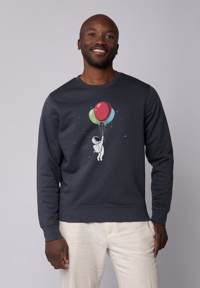 Donkerblauwe sweatshirt met een afbeelding van een astronaut die kleurrijke ballonnen vasthoudt. Heeft lange mouwen en een ronde halslijn, gemaakt van zacht materiaal.