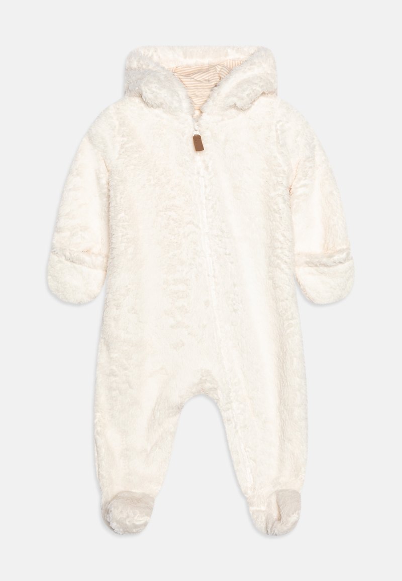 Un combinaisons en polaire de couleur crème avec un extérieur texturé et duveteux, doté d'une doublure à capuche rayée et d'une fermeture éclair à l'avant. Manches et pieds côtelés.