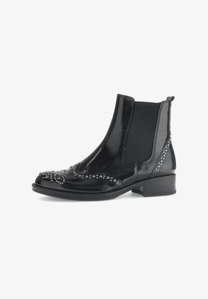 Svarta lackläder Chelsea-boots med elastiska sidor, prydda med silverfärgade nitar längs tån och hälen. Låg klack för stöd.