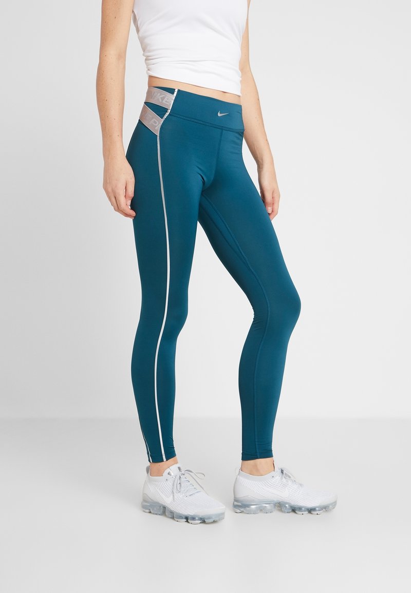 Tealowe legginsy sportowe z wysokim stanem, kontrastującym jasnoszarym paskiem po boku i akcentami z logo. Gładki, elastyczny materiał dla wygody.