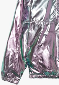 Metalicky stříbrno-fialový péřový kabát s lesklým povrchem, elastickými manžetami, prošívanými částmi a bočními kapsami.