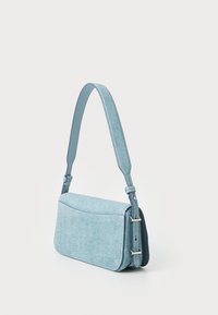 Blue denim crossbody bag with a structured design, adjustable handle, and silver hardware accents. Smooth, textured fabric finish.
