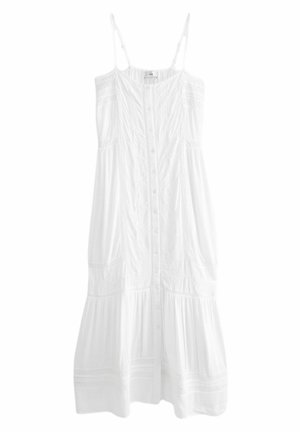 Robe midi blanche sans manches avec fines bretelles, fermeture à boutons sur le devant et détails subtils en dentelle sur tissu en coton.