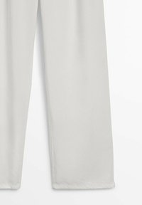Pantalon gris clair à coupe droite, montré de la mi-cuisse jusqu'à l'ourlet sur un fond blanc.