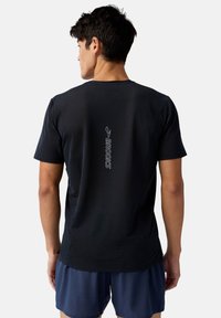 Svart sporttröja med en strukturerad design, med en reflekterande "BROOKS"-logotyp vertikalt på ryggen. Korta ärmar och rundad halsringning.