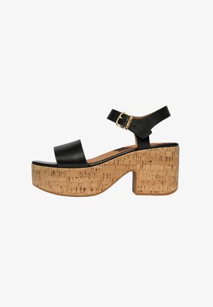 Black platform sandals with a cork block heel, featuring a wide front strap and ankle strap secured by a gold-toned buckle.