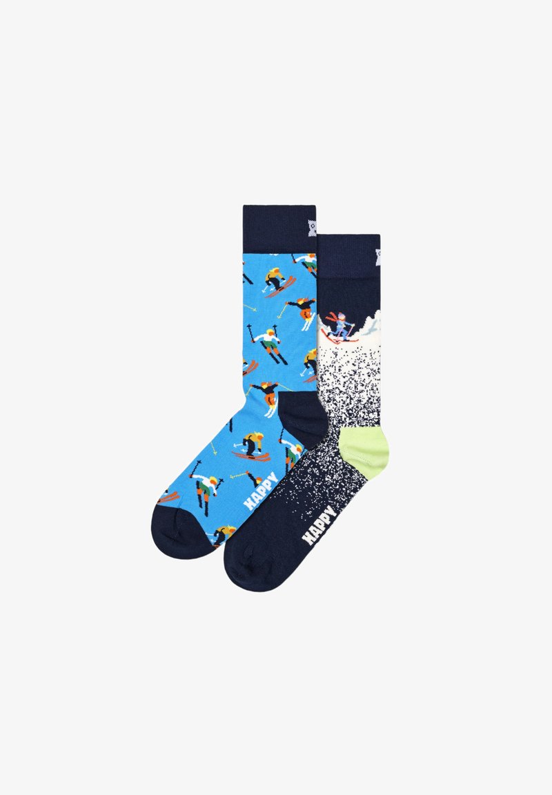 Blaue und marineblaue Socken mit bunten Skifahrfiguren, strukturierten Mustern und Logo-Details. Eine Socke hat einen grünen Akzent und ein Spritzdesign.