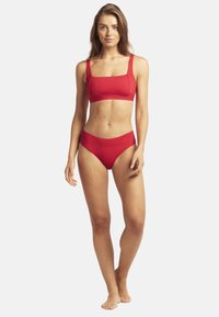 Czerwony zestaw bikini z kwadratowym dekoltem, crop topem na grubych ramiączkach i wysokimi majtkami, wykonany z gładkiego, elastycznego materiału.