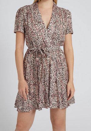 Frau trägt ein Kurzarm-Wickelkleid mit V-Ausschnitt, rosa-schwarzem Tierprint und gebundenem Taillengürtel.