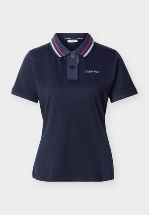 Tumesinine lühikeste varrukatega polo särk triibulise kraega, kahe nupuga ja väikese "Calvin Klein" logoga vasakul rinnal.