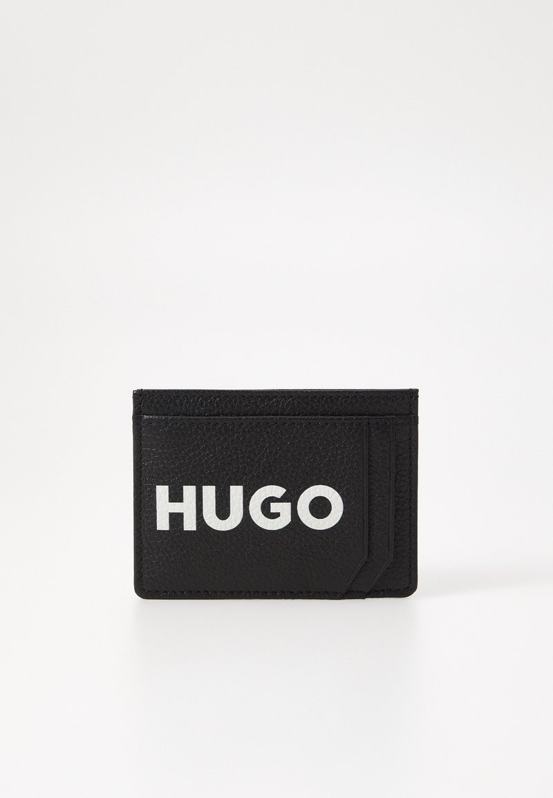Portafoglio in pelle nera con superficie texture, dotato di un prominente logo bianco "HUGO" e uno slot per carte davanti.