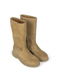 Botas altas de ante en color beige con una textura suave y puntera redonda, que presentan una suela de goma gruesa y detalles de costura mínimos.