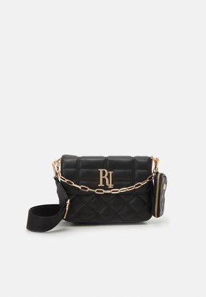 Zwarte gewatteerde crossbodytas met gouden kettinkdetail, afneembaar klein ritstasje en brede verstelbare band tegen een effen achtergrond.