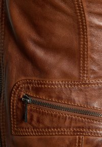 Smeđa kožna torbica s teksturiranim završetkom, istaknutim šavovima i zatvorenim džepom s crnim metalnim zatvaračem.