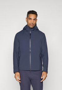 Navy blue waterproof jacket with a hood, front zipper, and side pockets. Smooth texture and minimal design with a fitted silhouette.