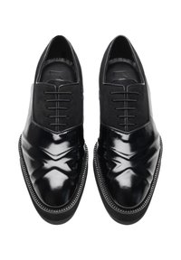Zwarte leren schoenen met een gepolijste afwerking, voorzien van een vetersluiting en getextureerde suède accenten, met een gebogen, gestikte zooldetail.