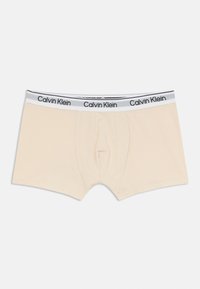 Beżowe bawełniane bokserki z czarno-białym paskiem z logo Calvin Klein. Posiadają płaski szew i wyprofilowaną kieszeń dla komfortu.