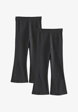 Dva pari črnih zvonastih hlač z elastičnimi pasovi, položeni na ravno proti belemu ozadju.