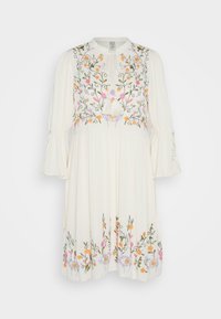 Vit klänning med blommönster i rosa, orange och lila. Har en rund halsringning, fransdetaljer och trumpetärmar. Utsvängd nederkant.