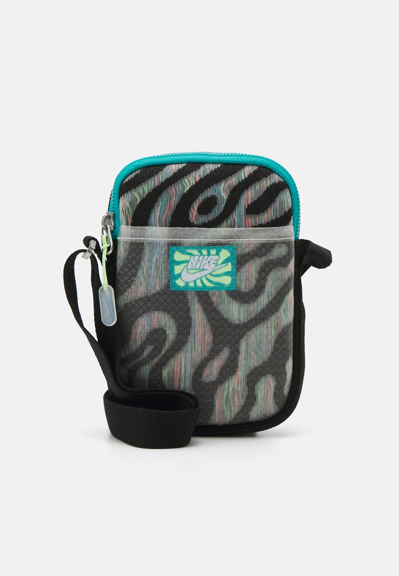 Hordozható Nike táska textúrával ellátott fekete és színes mintával, türkiz cipzárral és állítható fekete pánttal. Kiemelkedő logófolttal rendelkezik.