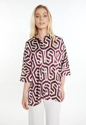 Blusa con motivo geometrico in una combinazione di colori bordeaux e bianco, design con bottoni, maniche a tre quarti, realizzata in un tessuto liscio.