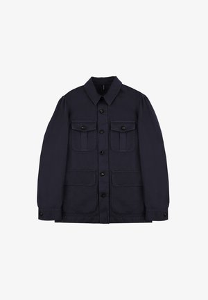 Chaqueta azul marino de una tela resistente que presenta un cierre frontal con botones, dos bolsillos en el pecho con tapetas y dos bolsillos frontales de parche.