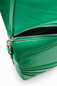 Groene leren handtas met een gestructureerde afwerking, voorzien van een ritssluiting en een schouderband. Interieur heeft een zwarte voering.