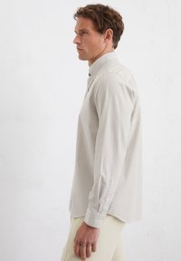 Gestreiftes Button-Up-Hemd in Beige/Weiß, mit langen Ärmeln, klassischem Kragen, aus weichem Baumwollstoff, mit taillierter Passform und Knopfmanschetten.