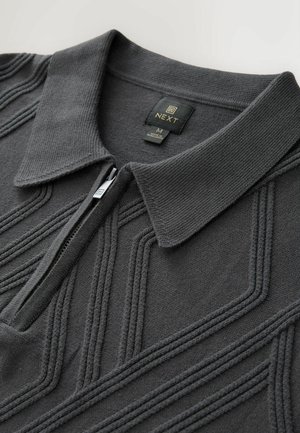 Dunkelgraues Zip-Polohemd mit einem strukturierten Strickmuster und klassischem Kragen. Verfügt über ein gesticktes Logo-Tag am Halsausschnitt.