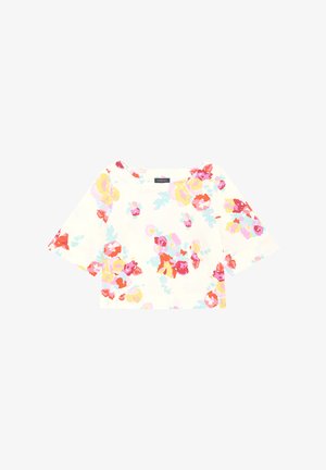 Blouse florale blanche ornée de fleurs vives roses, jaunes et bleues, avec des manches trois-quarts et un large col. Tissu doux et lisse.