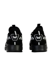 Baskets noires de sport avec un dessus texturé, accents blancs et un logo sur le talon. Équipées d'une semelle rembourrée et d'une tirette pour un enfilage facile.