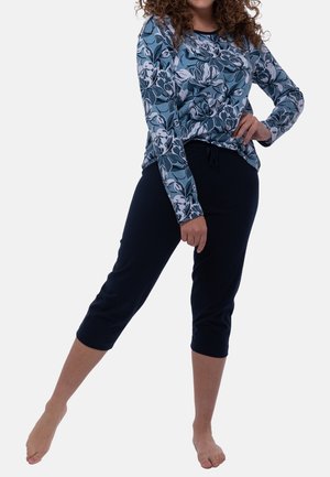 Blusenshirt mit langen Ärmeln in Blau und Weiß mit rundem Ausschnitt, kombiniert mit marineblauen, knöchellangen Hosen mit elastischem Bund.