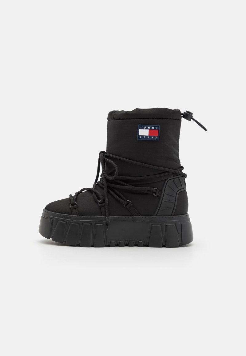 Černá vysoká zimní bota s tlustou podrážkou, omotanými tkaničkami, nastavitelným páskem na kotníku a logem Tommy Jeans na svršku.