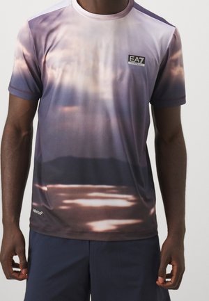 Homme portant un t-shirt à manches courtes avec un motif abstrait violet et marron et le logo EA7 sur la poitrine.