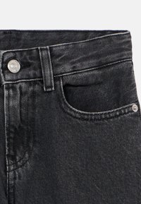 Sofisticados jeans de ganga pretos com um design clássico, bolso frontal, botão de metal prateado e costuras em contraste ao longo da cintura e dos bolsos.