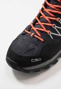 Schwarzer Wanderschuh mit grauen Akzenten, aus Wildleder und Mesh-Material, sichtbaren orangefarbenen Schnürsenkeln, strukturiertem Profil und Logo an der Seite.