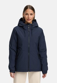 Mörkblå isolerad jacka med dragkedja, justerbar huva och två sidofickor. Har en slät yta och elastiska ärmslut.