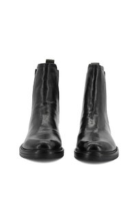 Bottines en cuir noir à la conception élégante, à bout pointu et à panneaux élastiques sur les côtés. Texture lisse et style minimaliste. Semelle en caoutchouc.